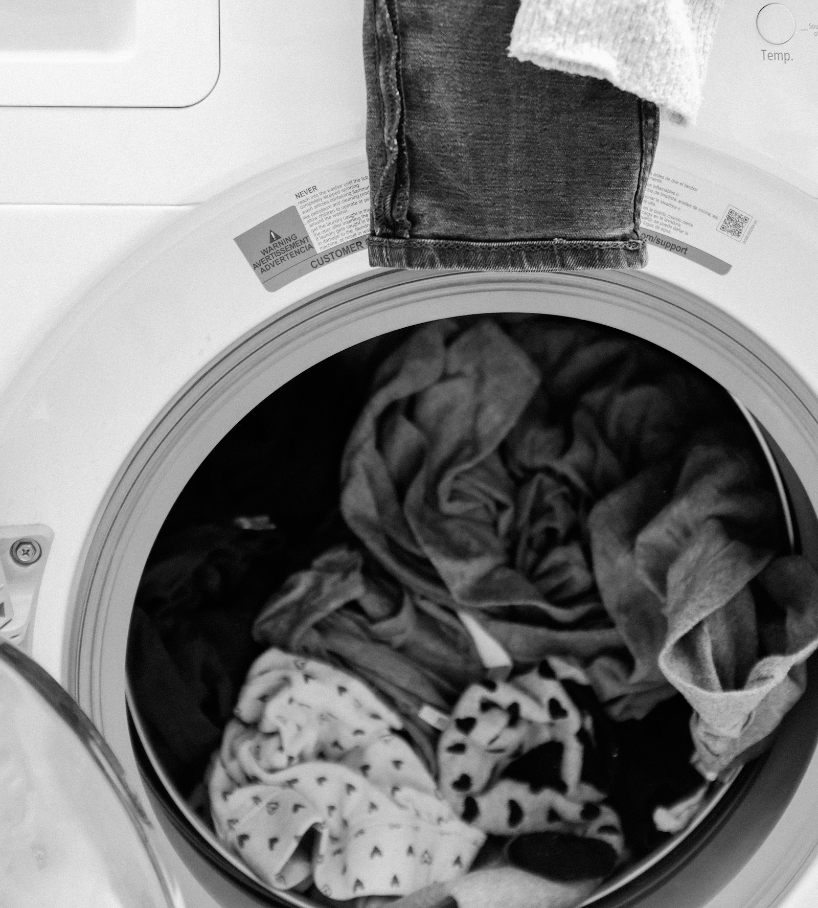 Tambor de una lavadora con ropa, en blanco y negro